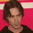 Static 48x48 pixel icon showing a person with brown curly hair against a pink and white striped background, wearing a dark top.