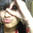 Pixelated close-up of a person with light skin, dark hair, and pink lips wearing a dark top against a blurred background.
