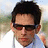 A pixelated image of a person with dark hair and sunglasses, wearing a white shirt, with blue text on light blue and gray backgrounds.