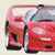 A red car with open driver's side door on light beige background, next to green text reading 'Original Icons .com' in pixelated font.