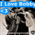 A pixelated image shows two figures embracing under blue text reading "I Love Bobby" with a blue heart symbol, where the right figure's head position shifts slightly between frames.