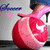 A red pomegranate with a white crescent and star symbol on its surface, held by a hand in the background.