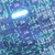 A pixelated blue-toned image with a bright white horizontal streak across the upper center, surrounded by varying shades of blue and teal in a mosaic pattern.