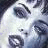 Pixelated close-up of a face with dark eyes, light skin tones, and visible eyebrows against a blurred background.