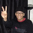 Pixelated image shows a hand making peace sign and a person with light hair wearing red collar against dark background.