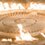 A static image with a pixelated, sepia-toned background featuring indistinct shapes and light patches, lacking clear subjects or text.