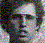 Pixelated static image of a person's face with dark hair and light skin, rendered in low-resolution mosaic style.