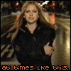 A woman with long blonde hair in a black coat stands on a city street at night, her arms crossed and expression shifting between frames.