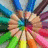 Colorful pencil tips radiate from a central point in a circular pattern, with visible color transitions between adjacent pencils.