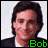 Pixelated portrait of a person with dark hair and a dark jacket over a light shirt, with green text reading 'Bot' in the bottom-right corner.
