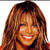 A static pixelated image of a person with long brown hair, smiling, wearing a red garment against a white background.
