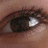 A close-up of a human eye with visible eyelashes and skin texture, paired with text elements on adjacent