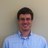 Pixelated static image of a person with short dark hair wearing a light blue collared shirt against a neutral background.