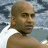Static image of a person with short hair against a cloudy sky background, next to green text reading 'OriginalIcons.com' on dark green.