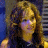 Animated contact sheet showing three sequential frames of a woman with long brown hair in a dark sleeveless top against a blue background with vertical stripes, displayed on a gray transparency background.
