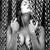 A grayscale pixelated image shows two figures in a dark, patterned background with a bright light source above them.
