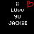 Pixelated text and symbols on black background with red heart symbol above 'LUUV YU' and 'JACKiIE' in white block letters.