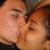 Two people in close proximity with eyes closed, sharing a kiss; one has light brown hair and the other dark brown hair.