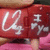 Red background icon with white stylized text and a small gray symbol on the right side.