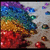 Pixelated abstract composition with layered color bands transitioning from purple and blue at top to green, yellow, orange, and red at bottom against light gray background.