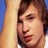 Pixelated close-up of a person's face with brown hair, visible eyes and lips against a blurred background.