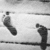 Black-and-white animation of a figure holding a long object, transitioning to a rainbow gradient with scattered dots.