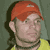 Pixelated static image of a person with red hair wearing a yellow shirt against a dark green background, rendered in low-resolution 8-bit style typical of early internet icons.