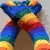 Rainbow-colored striped legs in a V-shape with brown background, cheese wedge, Spider-Man, banana, BFF text, and smiley face.