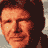 Pixelated static image of a person's face with orange-brown skin tones and dark hair against a gray background, rendered in low-resolution 256x256 pixels.