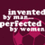 Pixelated text on a dark purple background reads 'invented by man perfected by woman' with pinkish-red abstract shapes below the words.