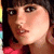 Pixelated close-up of a person with dark hair and light skin wearing a red garment, set against a dark background with colorful vertical stripes on the left.
