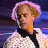 Pixelated static image of a person with light brown hair wearing a white shirt and black bow tie against a dark blue background.