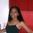 A static image shows a person with long dark hair wearing a dark sleeveless top against a red and white background.
