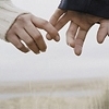 Two hands reach toward each other against a light background, fingers extended in a near-touch gesture.