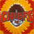Pixelated image of a character with brown hair and a red outfit against a fiery orange-yellow background with the word "CHIEF" in large red letters.
