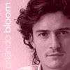 A static image of a person with curly hair against a pink background, with vertical text reading 'orlando bloom' on the left side.
