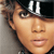 A pixelated close-up of a person's face wearing a dark cap with a white emblem, showing light skin tone, brown hair, and a neutral expression.