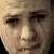 Pixelated close-up of a person's face showing eyes, nose, and mouth with light skin tone and dark hair visible at the edges.