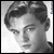 Black-and-white pixelated portrait of a person with styled hair, visible facial features including eyes and nose, and partial shoulder in grayscale tones.