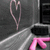 A pixelated image shows a pink heart shape above two white diagonal lines on a gray background, with a black rectangular area and pink curved line in the lower right.