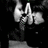 Black background with red pixelated text and a grayscale image of a person holding a microphone.