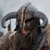 A pixelated figure with large curved horns, dark fur, and a red mouth against a light background.