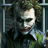 A pixelated image of a character with white face paint, red lips, and dark hair behind bars in a green shirt.