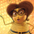 Pixelated character with brown hair and glasses, wearing a yellow shirt and dark belt, against a warm-toned gradient background.