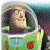 Pixelated image of a character in a green and purple spacesuit with a clear helmet, smiling with visible teeth, against a blurred background.