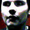 Two side-by-side pixelated faces with high-contrast black-and-white rendering, showing subtle mouth and eye expression differences.