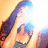 Pixelated static image of a person with long dark hair, light skin, and a dark top against a warm-toned gradient background.