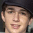 A pixelated image shows a person wearing a dark cap on the left, with a black background on the right displaying white text.