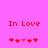 Pixelated red text "In Love" on bright pink background with two of pixel hearts, one showing animation change in heart positions