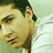 Pixelated close-up of a person's face with dark hair, light skin, and a neutral expression against a pale green background.
